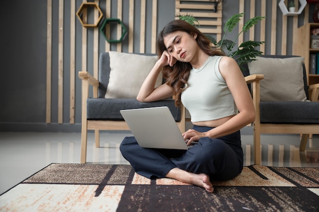 Asia woman serious of work from home with computer in living room at home