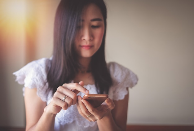 Asia woman using mobile phone for checking social media and success of business