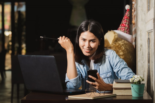 Asia woman using smartphone,personal computer  working  with happy.