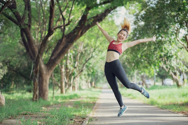 Asia women listen to music during a workout at the park.