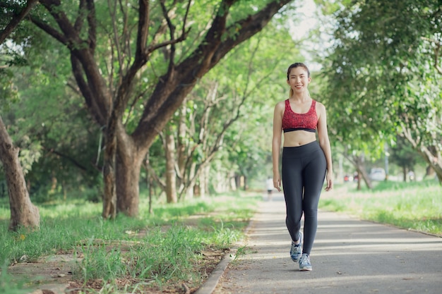 Asia women listen to music during a workout at the park.