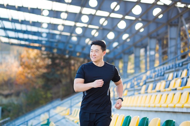 Asian athlete on a morning jog near the stadium successful male businessman is engaged in fitness in the morning before work