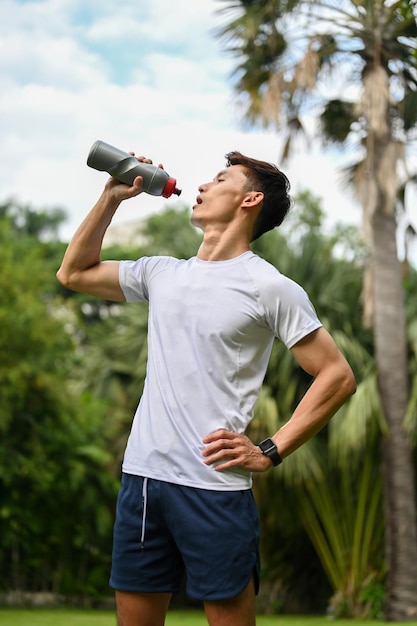 Asian athletic man drinking water from the bottle Thirsty Exhausted Dehydrated