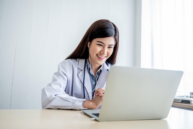 Asian attractive woman doctor Looking and using a computer notebook To provide advice to patients