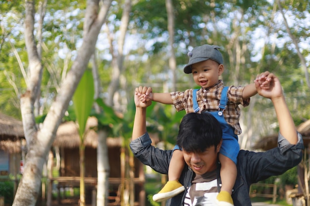 Asian baby boy riding on father's neck