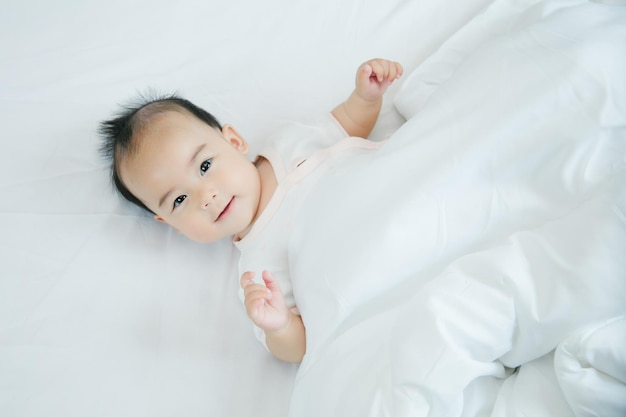 Asian baby lying on bed with soft blanket indoors cute little asian newborn baby