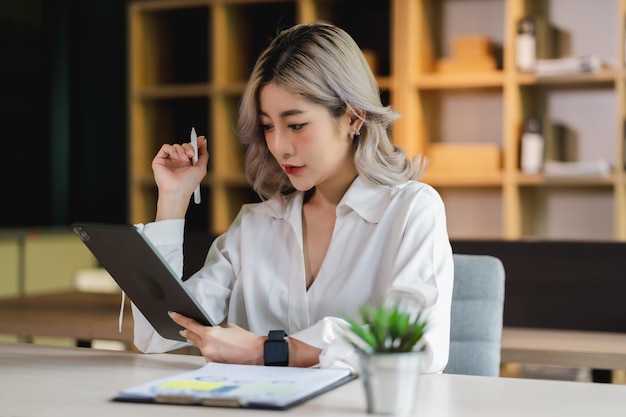 Asian beautiful businesswoman seriously working thinking idea for work on computer and think project for idea sitting work indoor