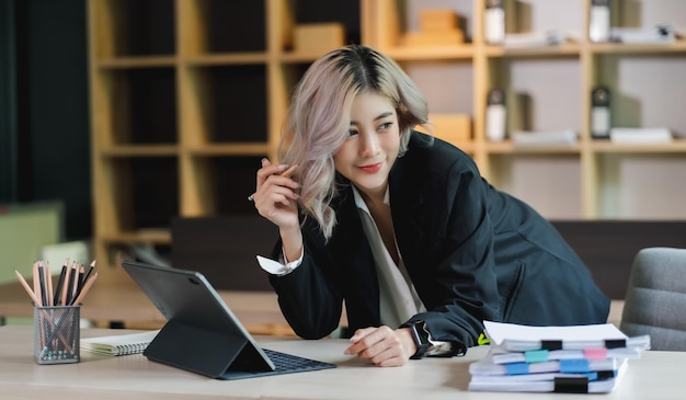 Asian beautiful businesswoman seriously working thinking idea for work on computer and think project for idea sitting work indoor