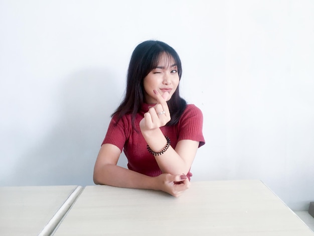 Asian beautiful smiling girl showing love korea sign with finger with blurred background isolated white background Indonesian Women