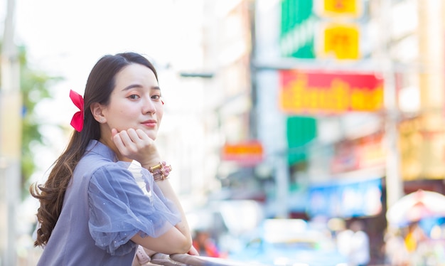 Asian beautiful woman in bluegrey Qipao dress is standing smilie happy Roadside China Town