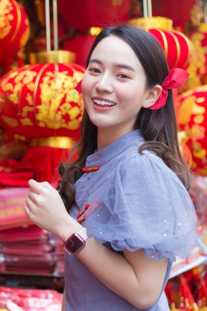 Asian beautiful woman in long hair wears a grey Chinese dress or qipao with Chinese new year theme