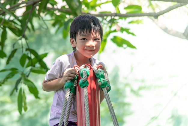 Asian boy climbing up the top of the playground 