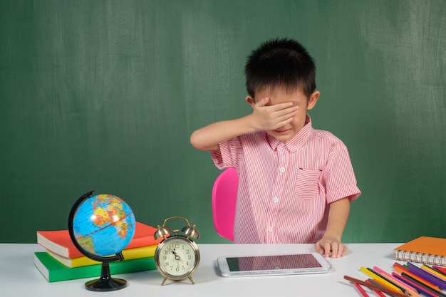 Asian Boy crying in chalk board room 