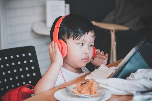 Asian boy listening music in headphones at home.Close up