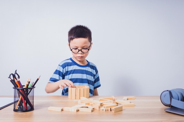 Asian boy playing with a wooden puzzle