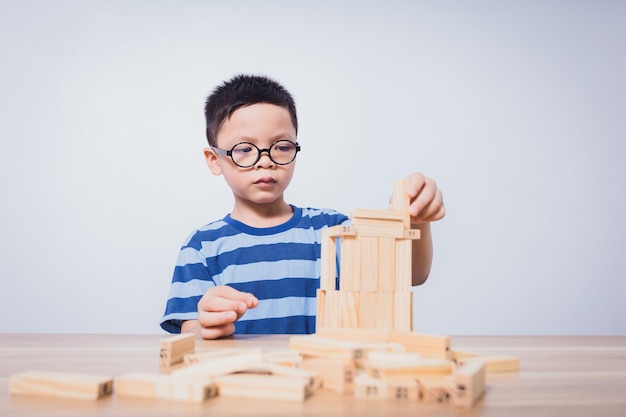 Asian boy playing with a wooden puzzle