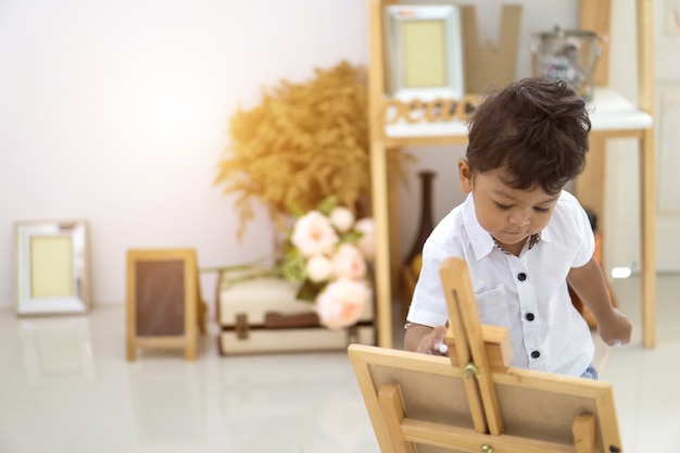 Asian boy writing on a blackboard.