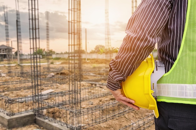 Asian business man construction engineer worker in protective helmet and blueprints paper on hand at house building site