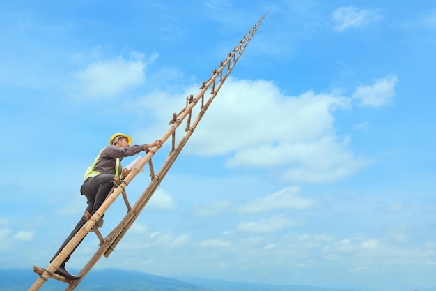 Asian business man engineer climbing up llong adder with blue sky career growth and success concept