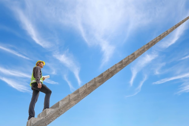 Asian business man engineer walking up stairway with blue sky career growth and success concept