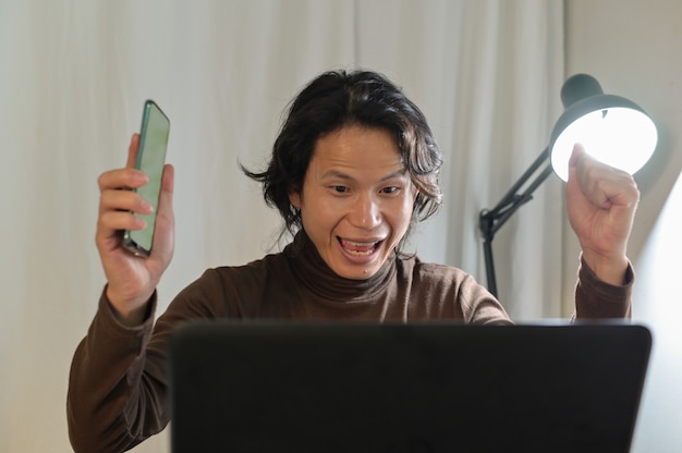 Asian business man looks very surprised at his laptop