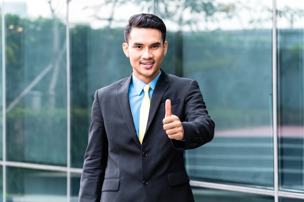 Asian business man walking in front of building