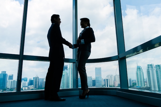 Asian business people shaking hands