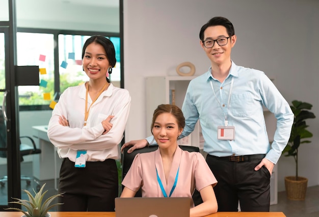 Asian business team of office colleagues standing together in boardroom