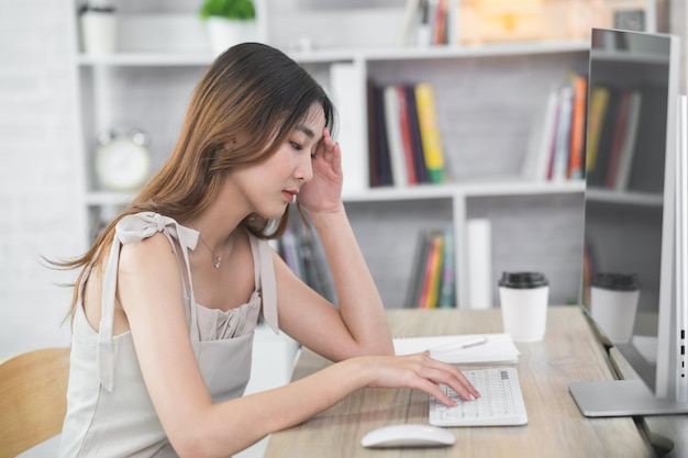 Asian business woman having stressful depression sad time working on laptop or computer on wood table at home office Depression man sad serios working from anywhere