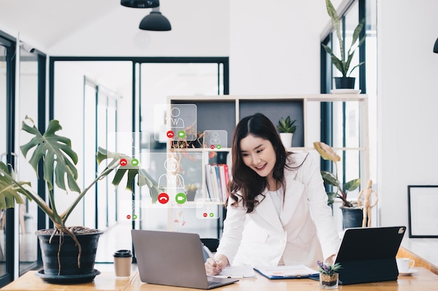 Asian business woman having video call with business team to consult about business plan of company Online team meeting video conference