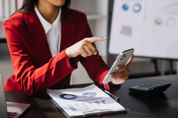 Asian Business woman using calculator and laptop for doing math finance on an office desk tax report accounting statistics and analytical research concept