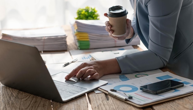 Asian Business woman using calculator and laptop for doing math finance on an office desk tax report accounting statistics and analytical research concept