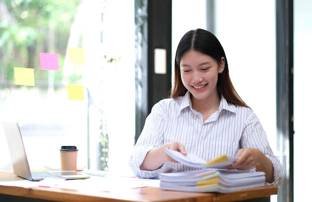 Asian business woman working in office with laptop paper work