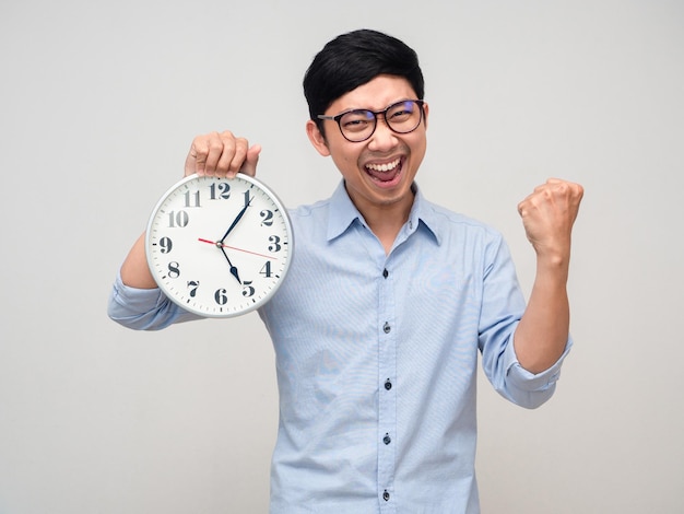 Asian businessman happy smile holding analog clock show fist up for success isolated