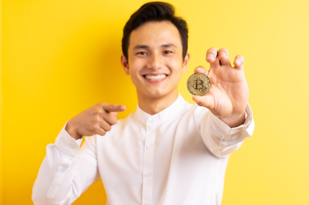 Asian businessman holding bitcoin in his hand wite happy face