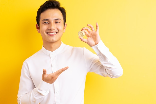 Asian businessman holding bitcoin in his hand wite happy face