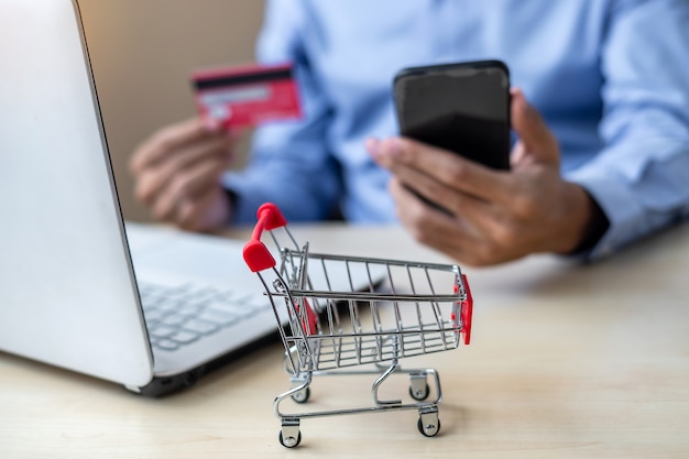 Asian businessman holding credit card using laptop and smart phone 