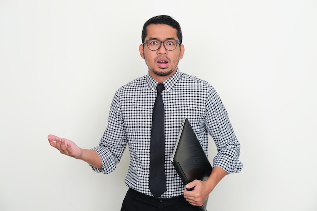 Asian businessman holding a laptop with shocked expression