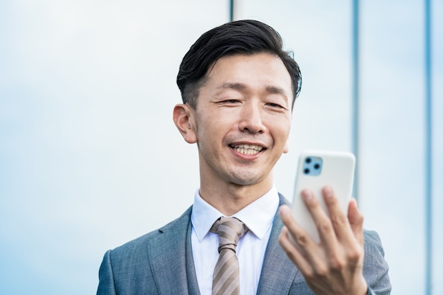 Asian businessman looking at a smartphone screen