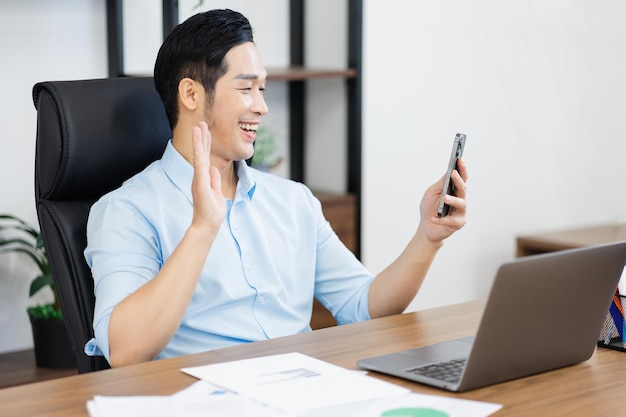 Asian businessman male portrait sitting at his desk