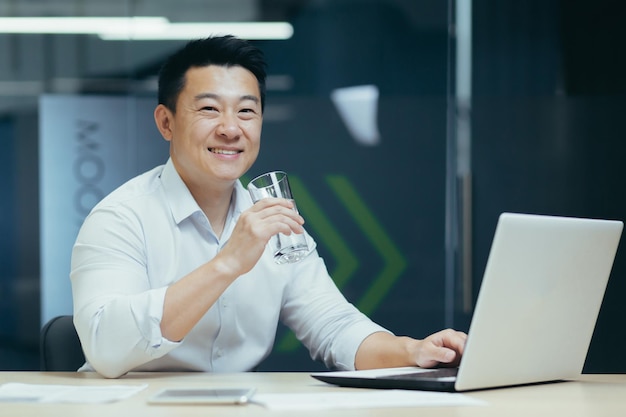 Asian businessman in the office drinking clean filtered water