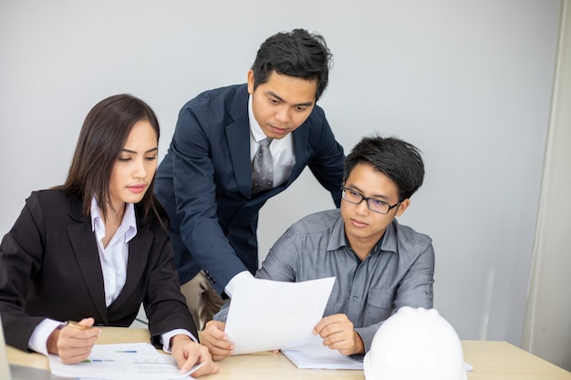 Asian businessmen and group using notebook for business partners discussing documents and ideas at meeting and business women smiling happy for working