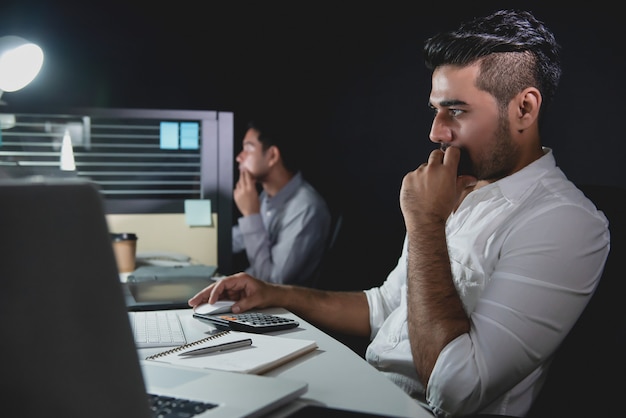 Asian businessmen staying overtime late at night working in the office 