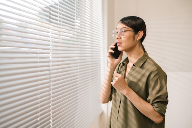 Asian businessperson talking on the phone in modern office LGBT 4k