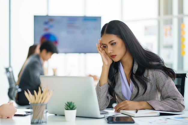 Asian businesswoman feeling stressful and headache after working for a long time Office syndrome concept