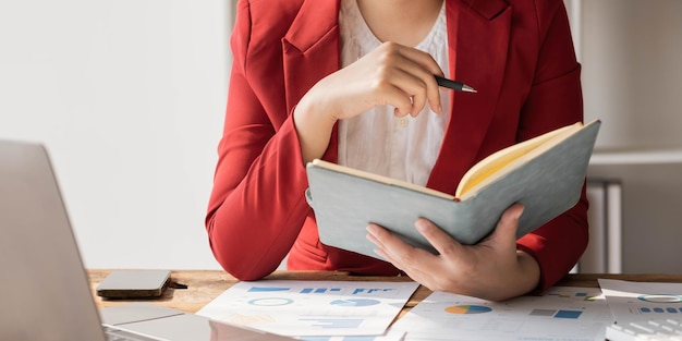 Asian businesswoman meeting at the office taking notes and using a tablet at the office