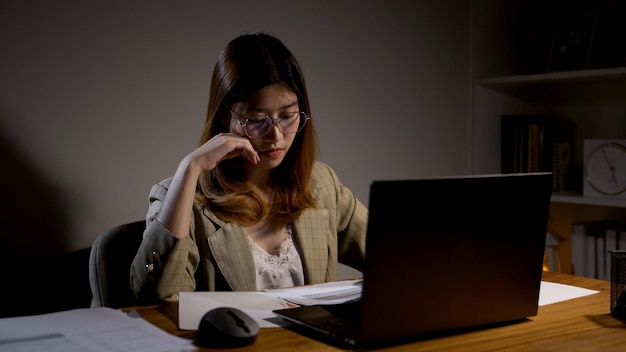 Asian businesswoman online working at the night. Busy and exhausted of work overtime at home