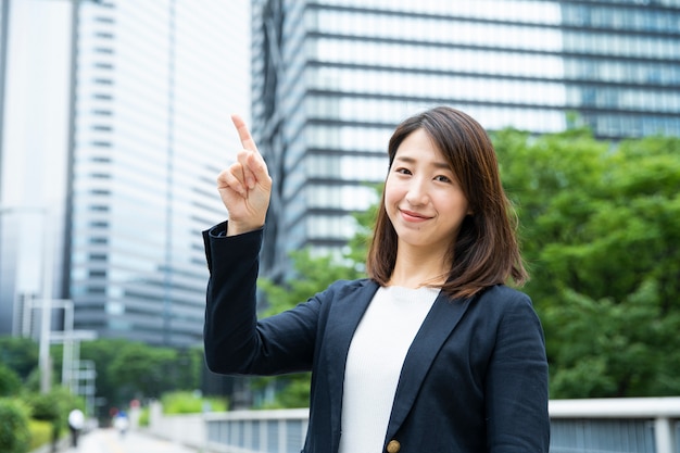 Asian businesswoman pointing up