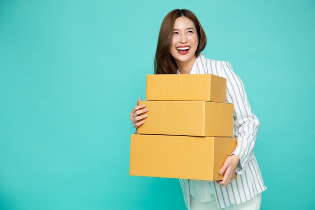 Asian businesswoman smiling and holding package parcel box isolated on green background