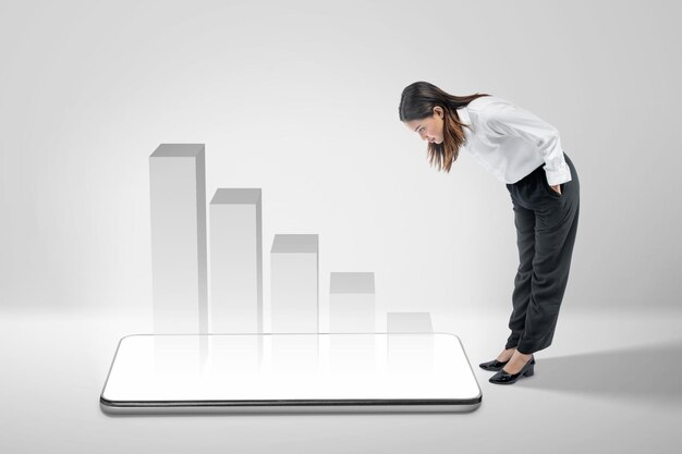 Asian businesswoman standing and looking at mobile phone